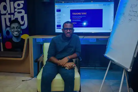 Nigerian digital marketer seated in thought at a digiTrybe training session, representing the in-house vs agency career decision