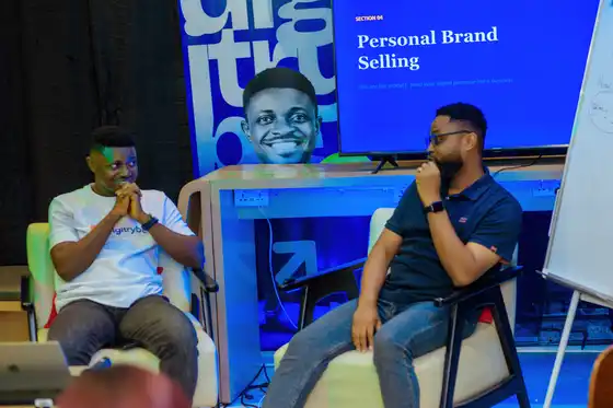 Two speakers in conversation on stage at a digiTrybe session on personal brand selling